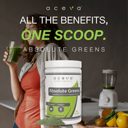A level scoop of Absolute Greens powder beside a glass of water